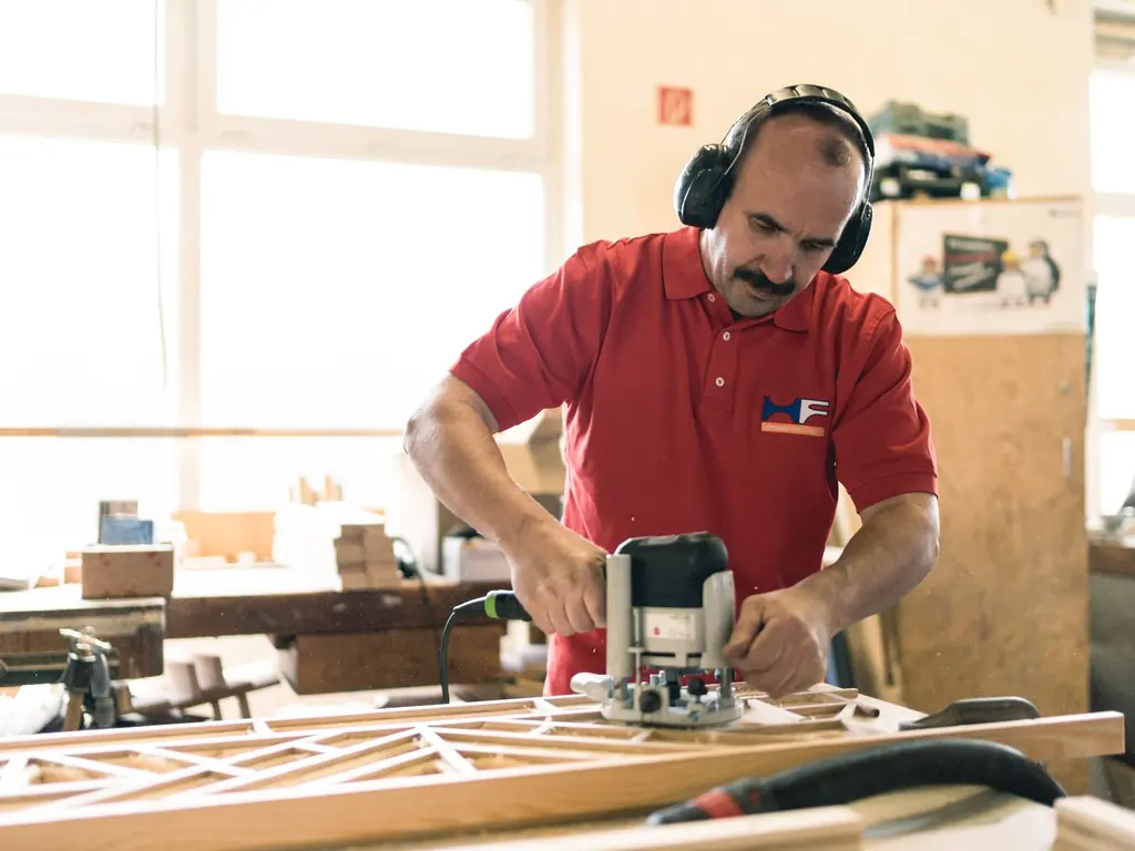 Schreiner fräst ein Werkstück in der Werkstatt